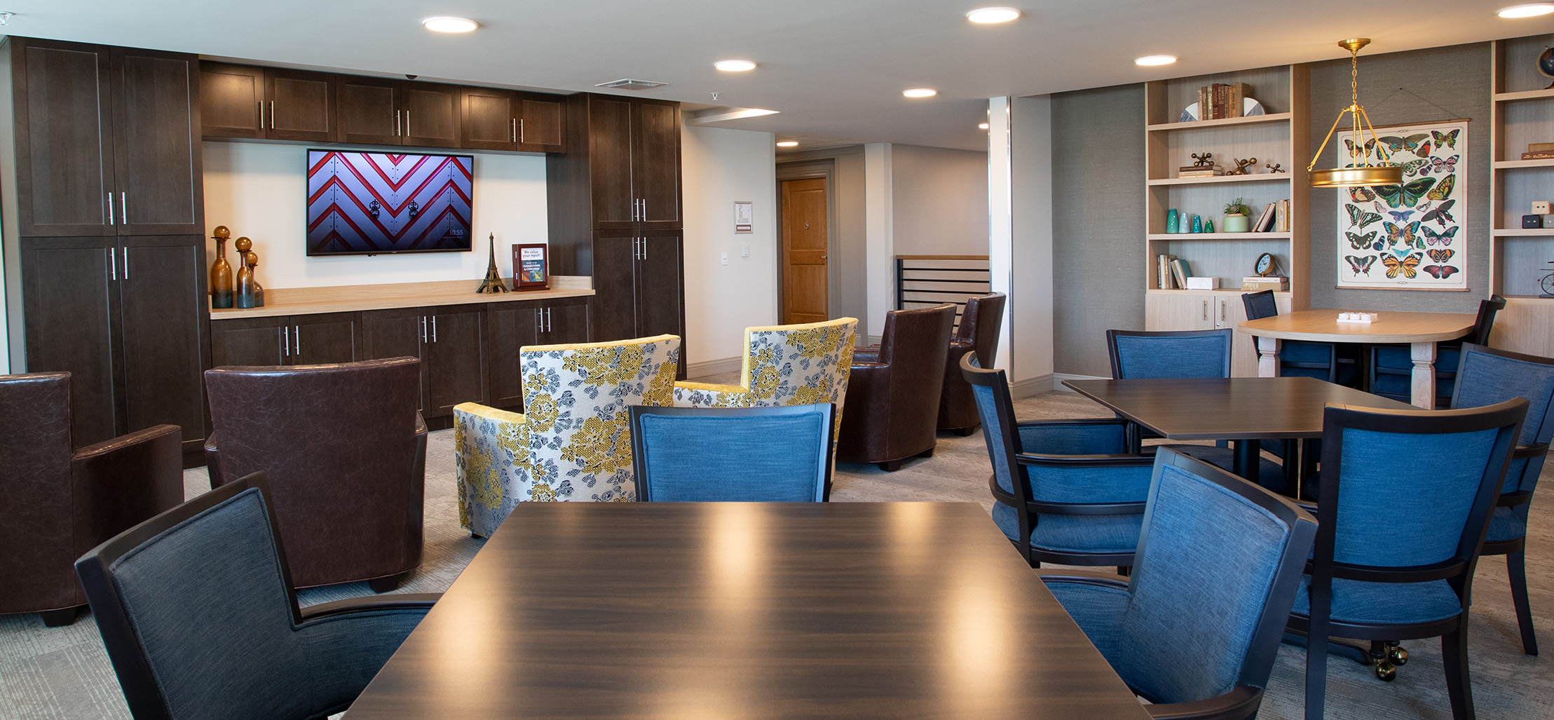 kitchen with dark brown cabinets and blue chairs - New Perspective Careers Assisted Living Careers