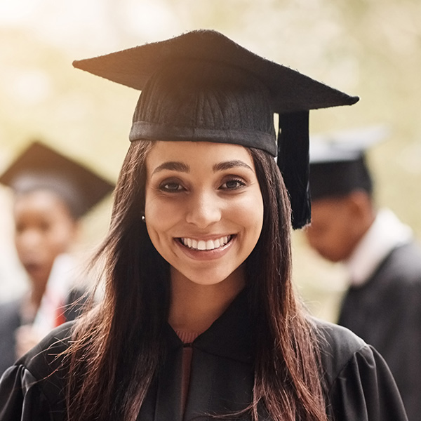 young woman wearing a black graduation cap and gown- New Perspective Careers Assisted Living Careers