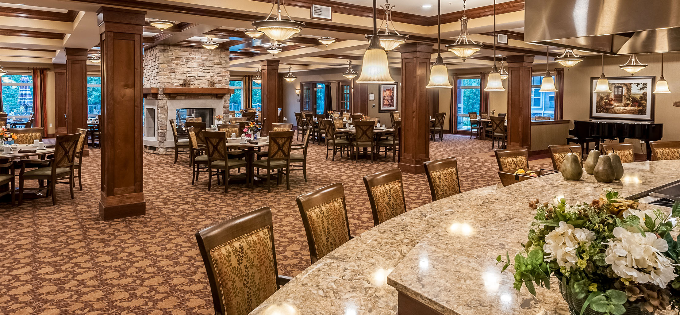 interior of facility with tables and a stone fireplace - New Perspective Careers Assisted Living Careers