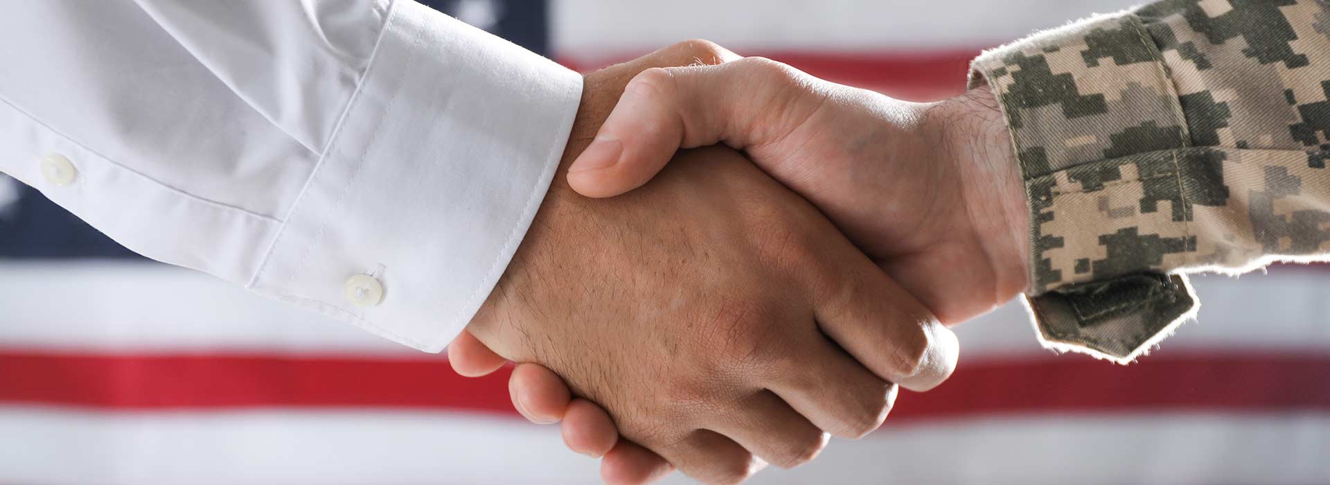 person in military uniform shaking hands with another person - New Perspective Careers Assisted Living Careers