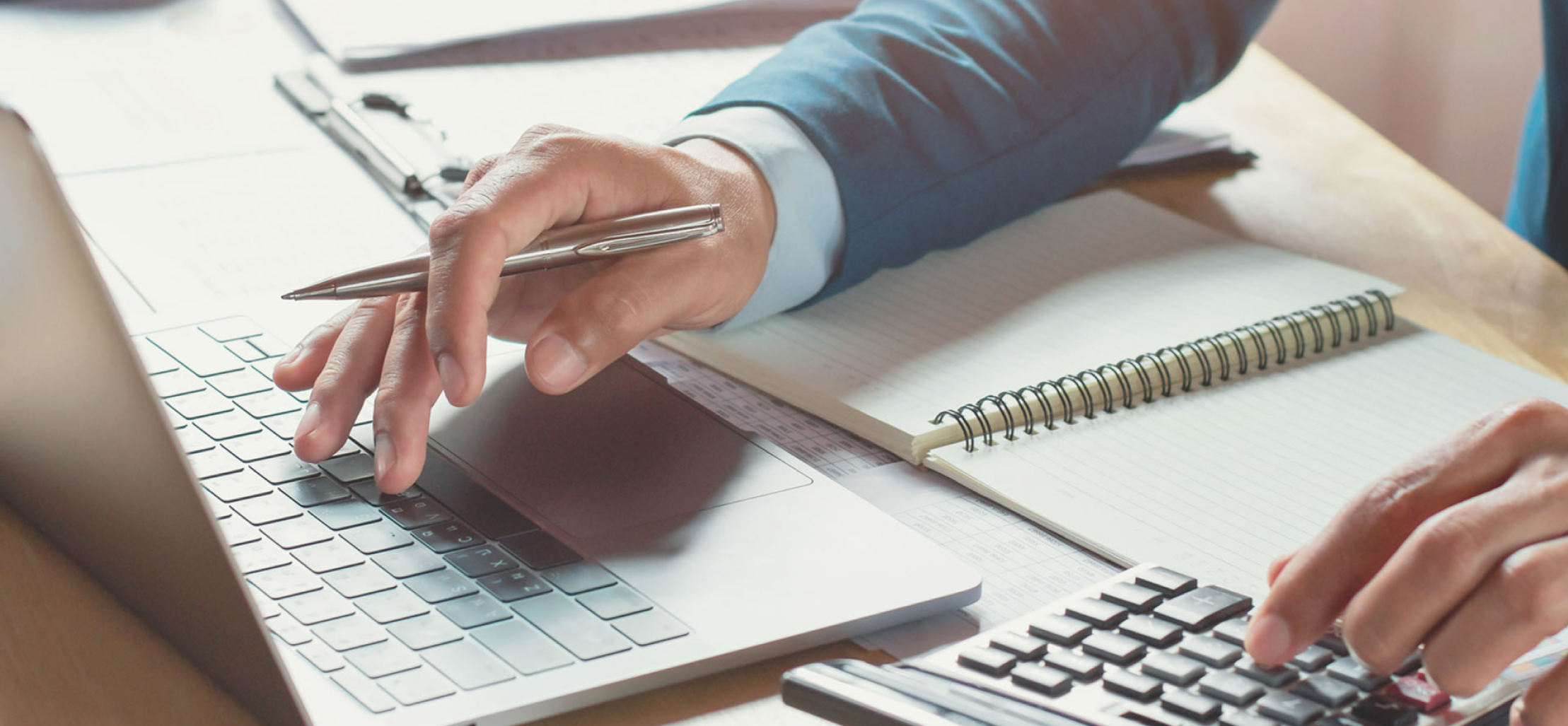 person working a calculator while on their laptop - New Perspective Careers Assisted Living Careers