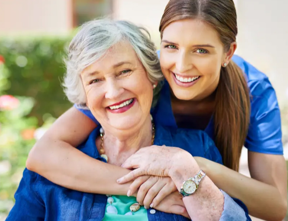 employee hugging elderly woman - New Perspective Careers Assisted Living Careers