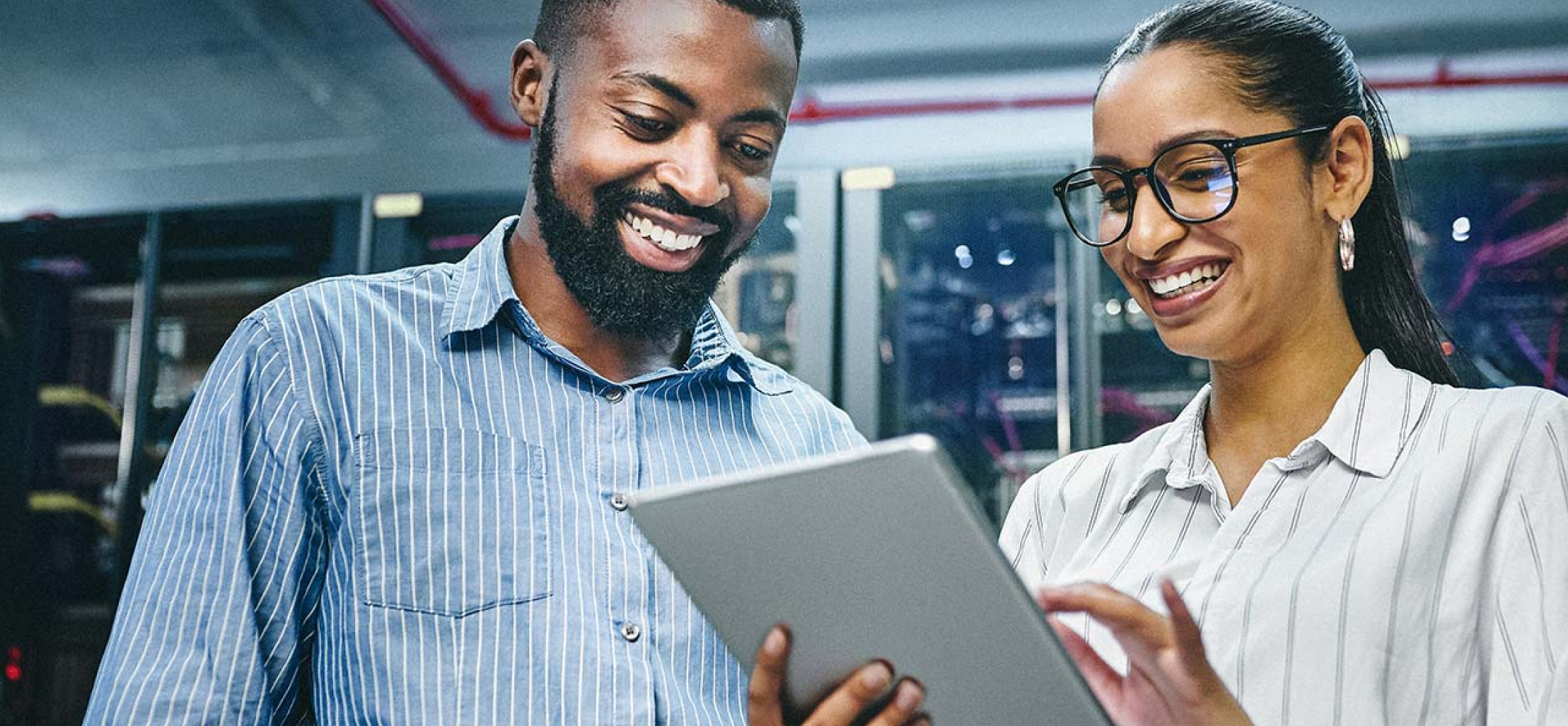 man and woman smiling at a tablet - New Perspective Careers Assisted Living Careers