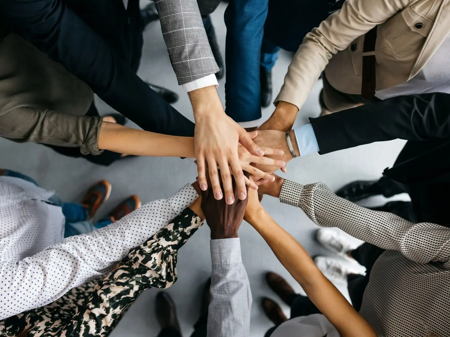 group of employees with their hands together - New Perspective Careers Assisted Living Careers