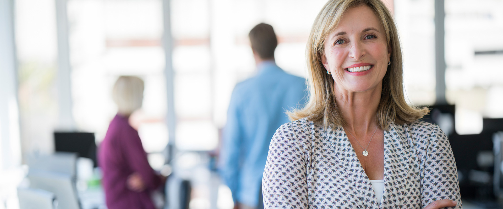 woman in a blazer smiling in office - New Perspective Careers Assisted Living Careers