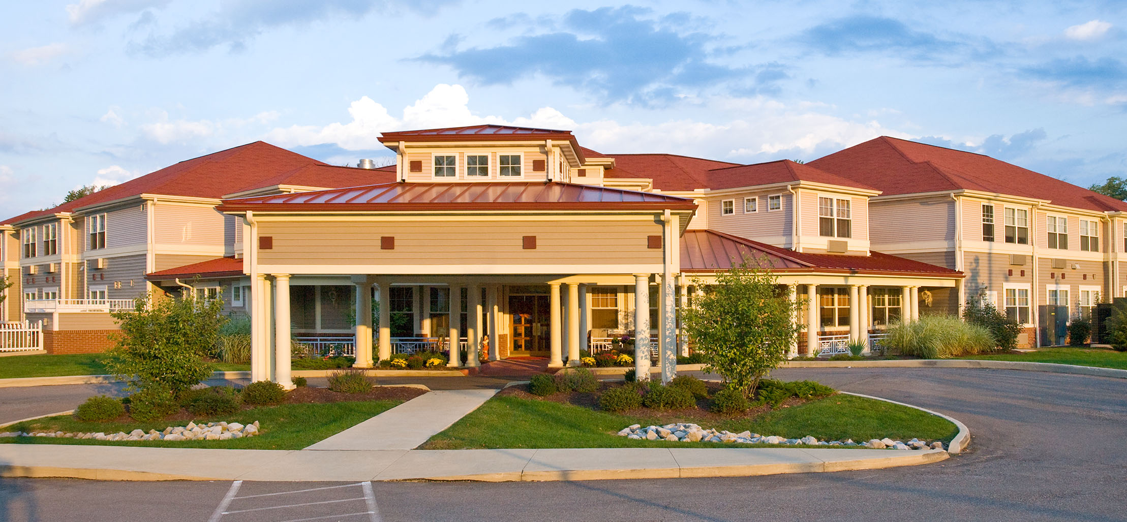 exterior of Southwest Commons facility with white columns and red metal roof - New Perspective Careers Assisted Living Careers