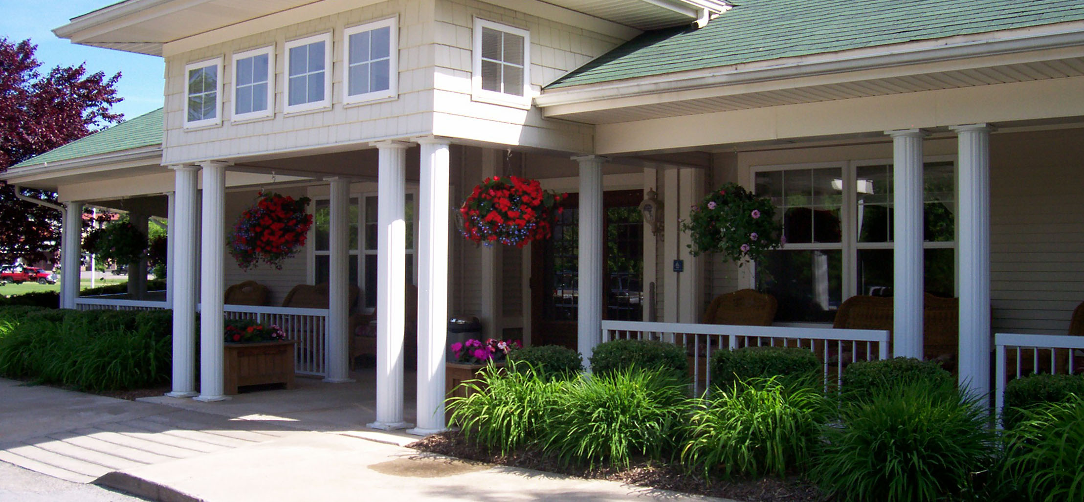 exterior of South Woods facility with white columns and green roof - New Perspective Careers Assisted Living Careers