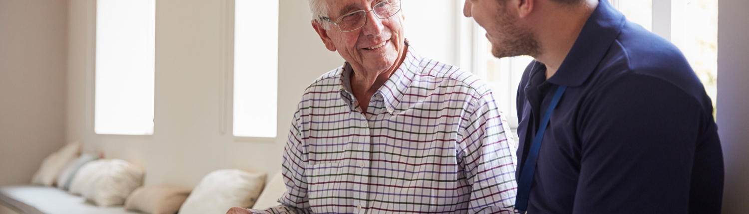 elderly man and employee looking through photo album - New Perspective Careers Assisted Living Careers