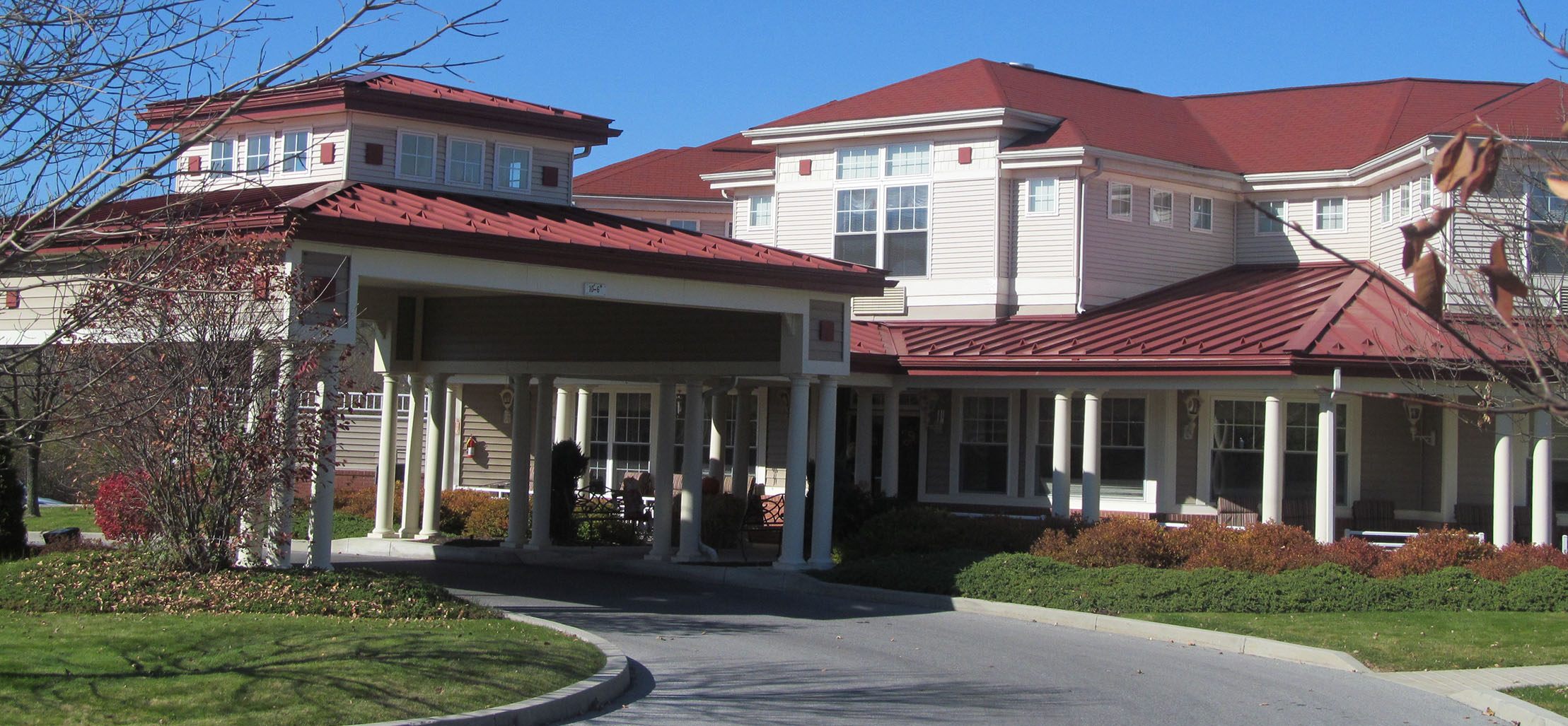 exterior of Winds Mattern Orchard facility with white columns and red metal roof - New Perspective Careers Assisted Living Careers